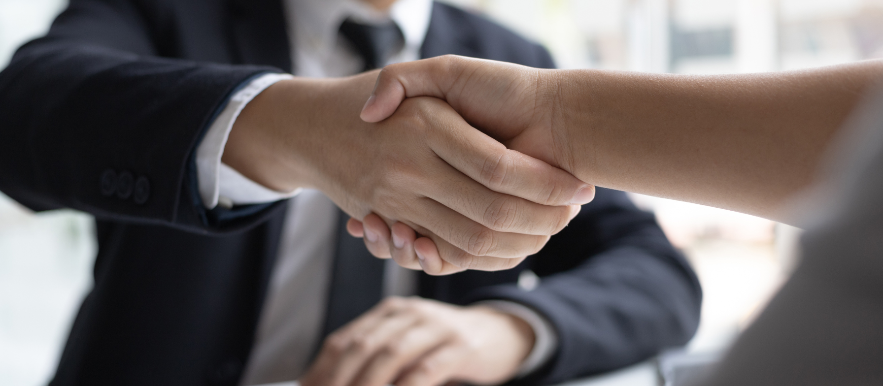 A hiring manager shaking hands with a new employee found by Concentric, a tech recruiting firm